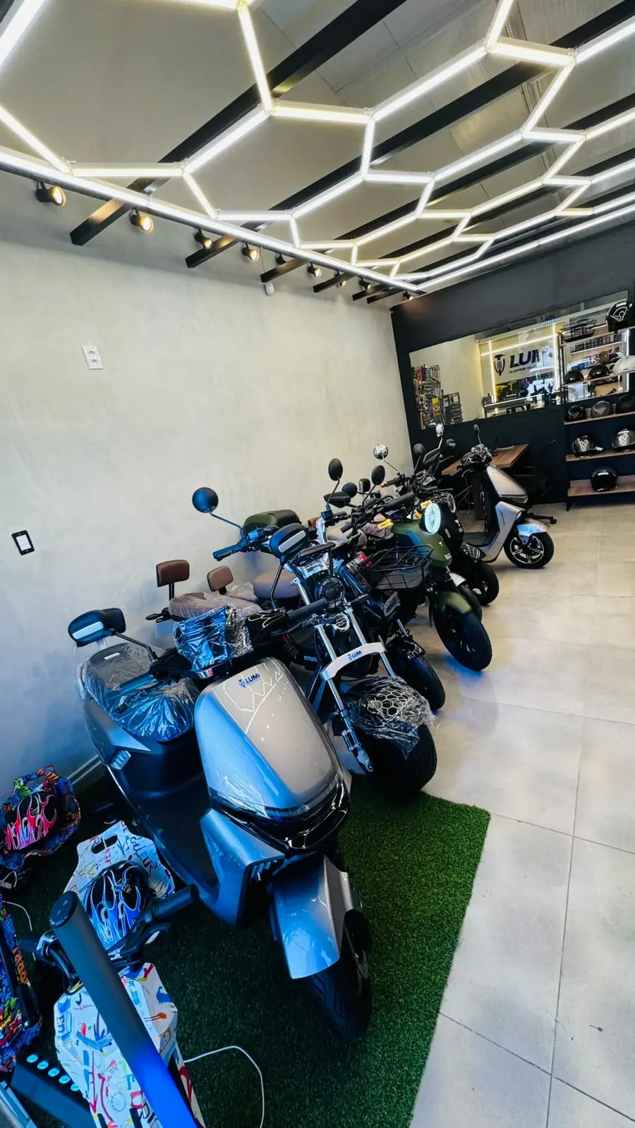 Interior do showroom da LUMI com scooters e motos elétricas enfileiradas